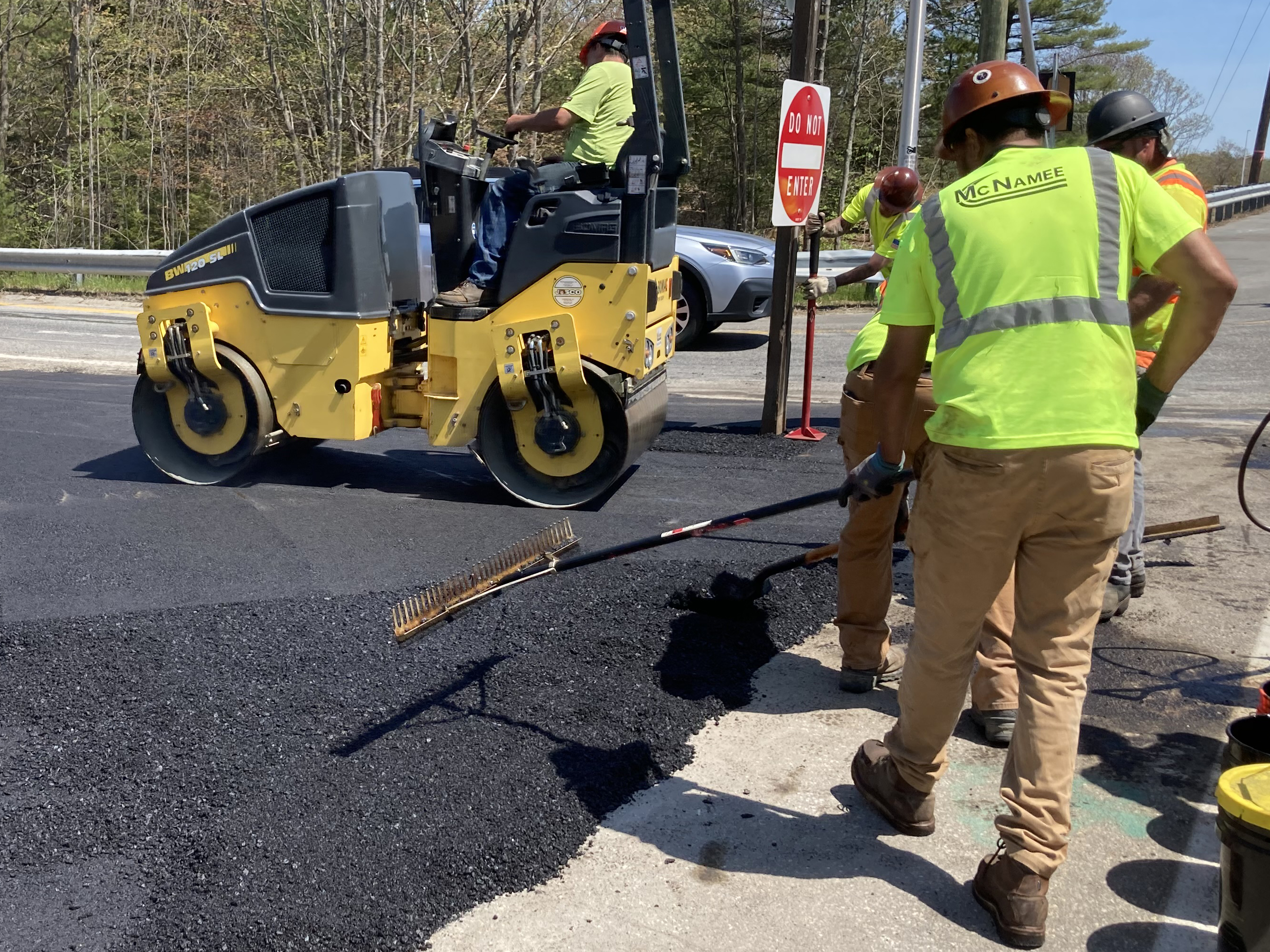 Workers spread new asphalt for the new temporary navigation.
